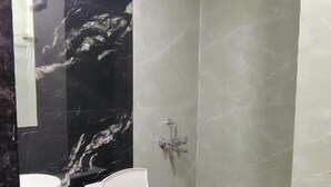 Moderni kylpyhuone, jossa on wc, pesuallas ja suihku.