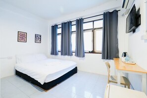A hotel room with a bed, a desk, a chair, and a TV on the wall. - zNAP Ekkamai (Bangkok)