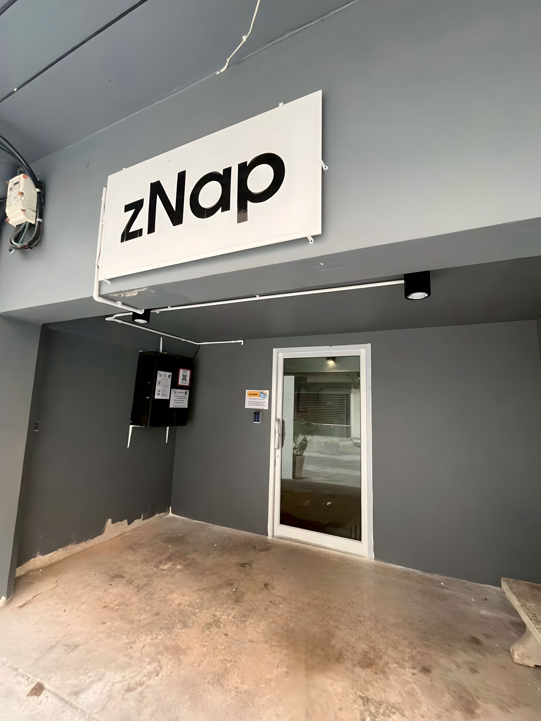 A building entrance with a sign reading 'zNap' and a door with a glass panel.