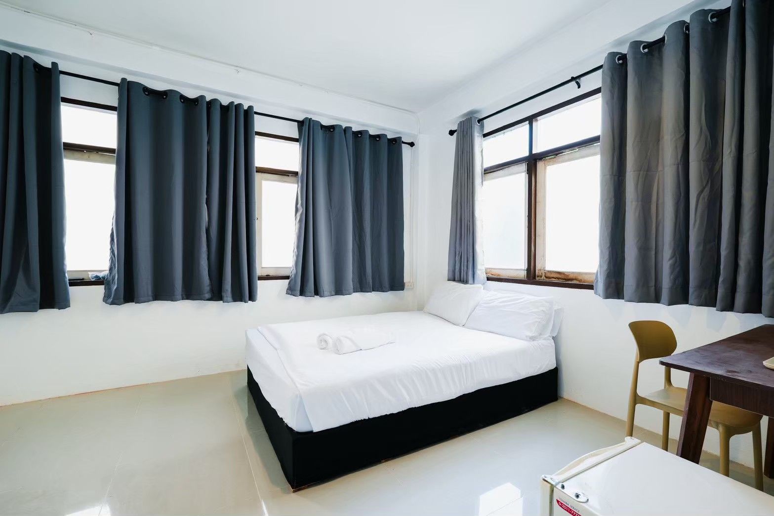 A bedroom with a bed, a desk, and two chairs.