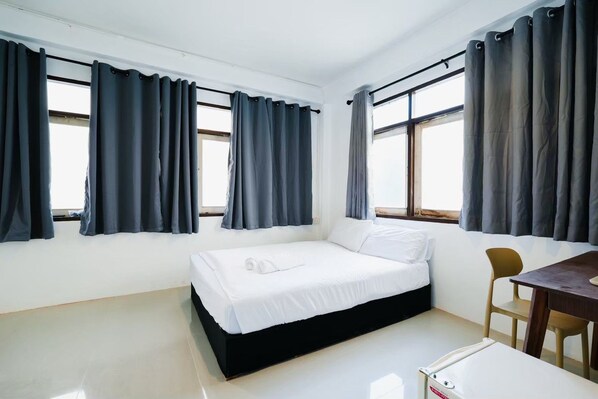 Ein Schlafzimmer mit einem Bett, einem Schreibtisch und zwei Stühlen.
