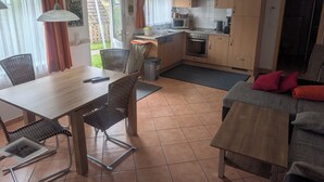 A compact living space with a dining area, kitchenette, and a sofa. - Sonneck vacation apartment for 4 people with direct access to the garden. (Feldberg (Schwarzwald))