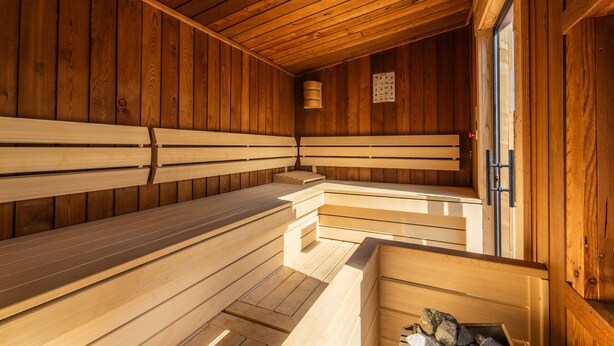 A sauna with wooden benches and a wooden ceiling. - Chalet Molly, garden & sauna (Zell am See)