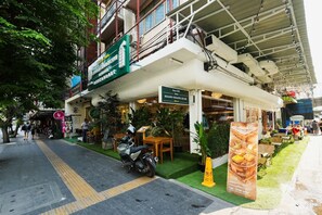 Un restaurant avec une terrasse, une moto garée devant et une enseigne.
