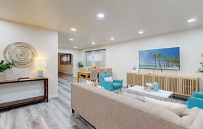 A modern living room with a sofa, armchairs, a coffee table, and a dining area with a table and chairs. - Gorgeous 4-bedroom house with Hot Tub in Huntington Beach I 31 nights + (Huntington Beach)