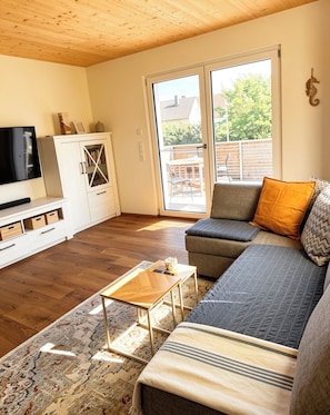 A living room with a sofa, a coffee table, a TV, and a cabinet.
