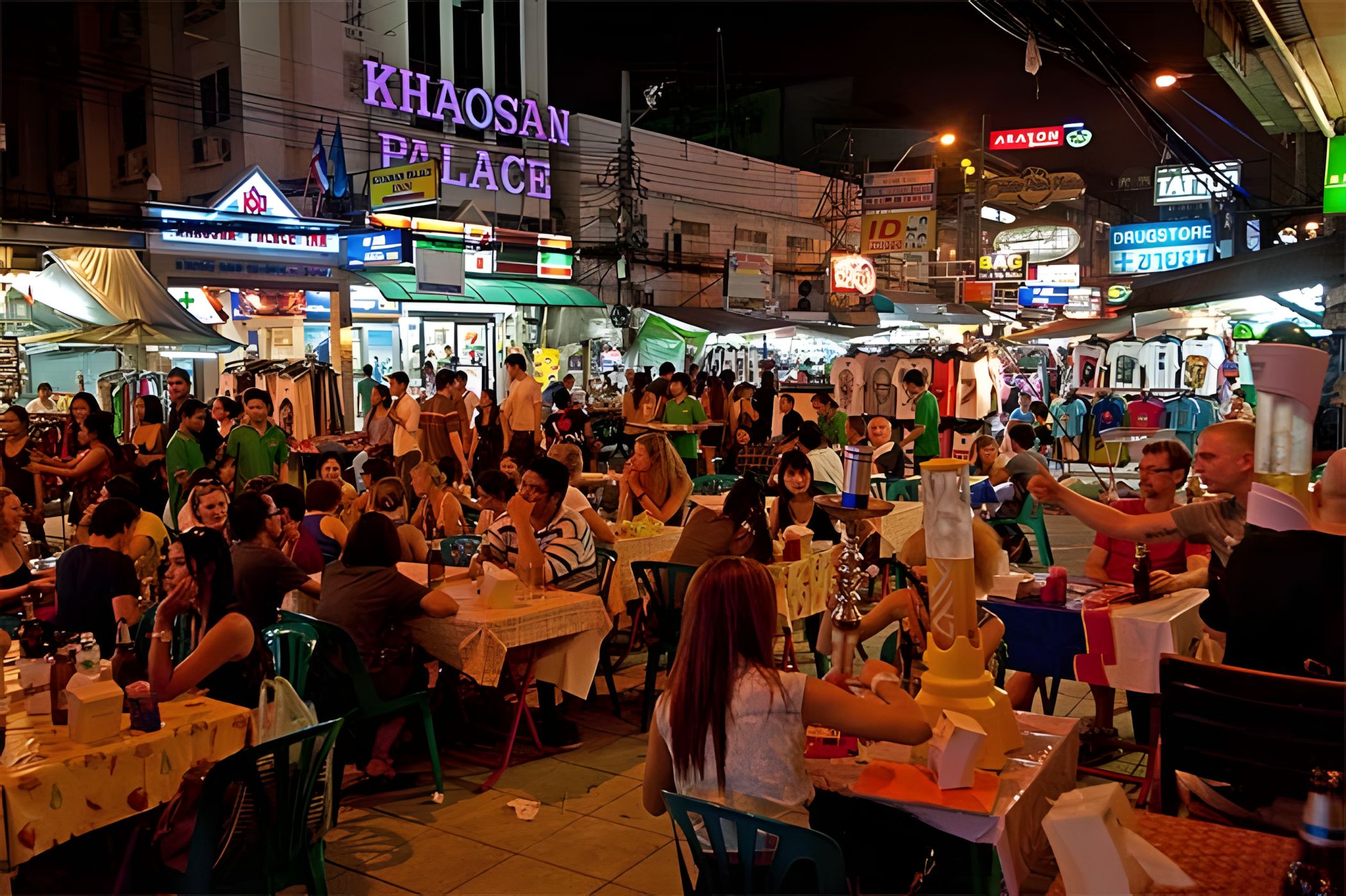 A crowded outdoor market with various stalls and tables.