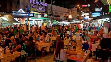 A crowded outdoor market with various stalls and tables.