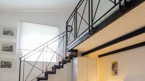 Ein Schlafzimmer mit Bett, Treppe und Fenster.