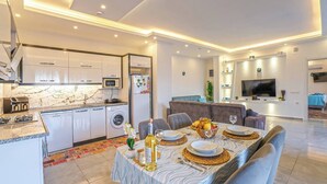 Una cocina moderna con microondas integrado, refrigerador y estufa a gas.