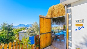 Un balcón con vista a montañas, una cerca de madera y un cartel que indica la habitación 57/2.