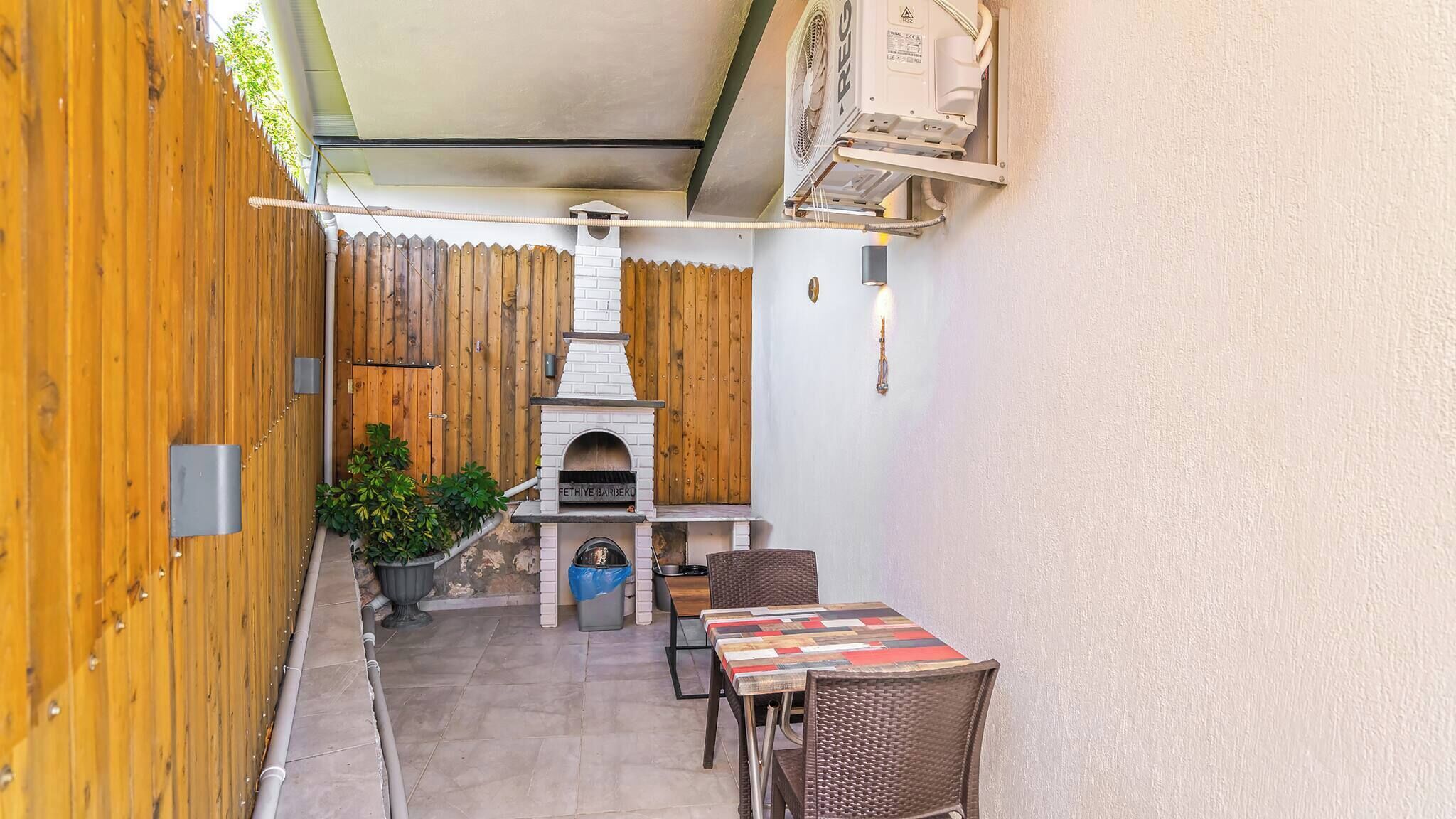 Un patio con una parrilla, una mesa y sillas.