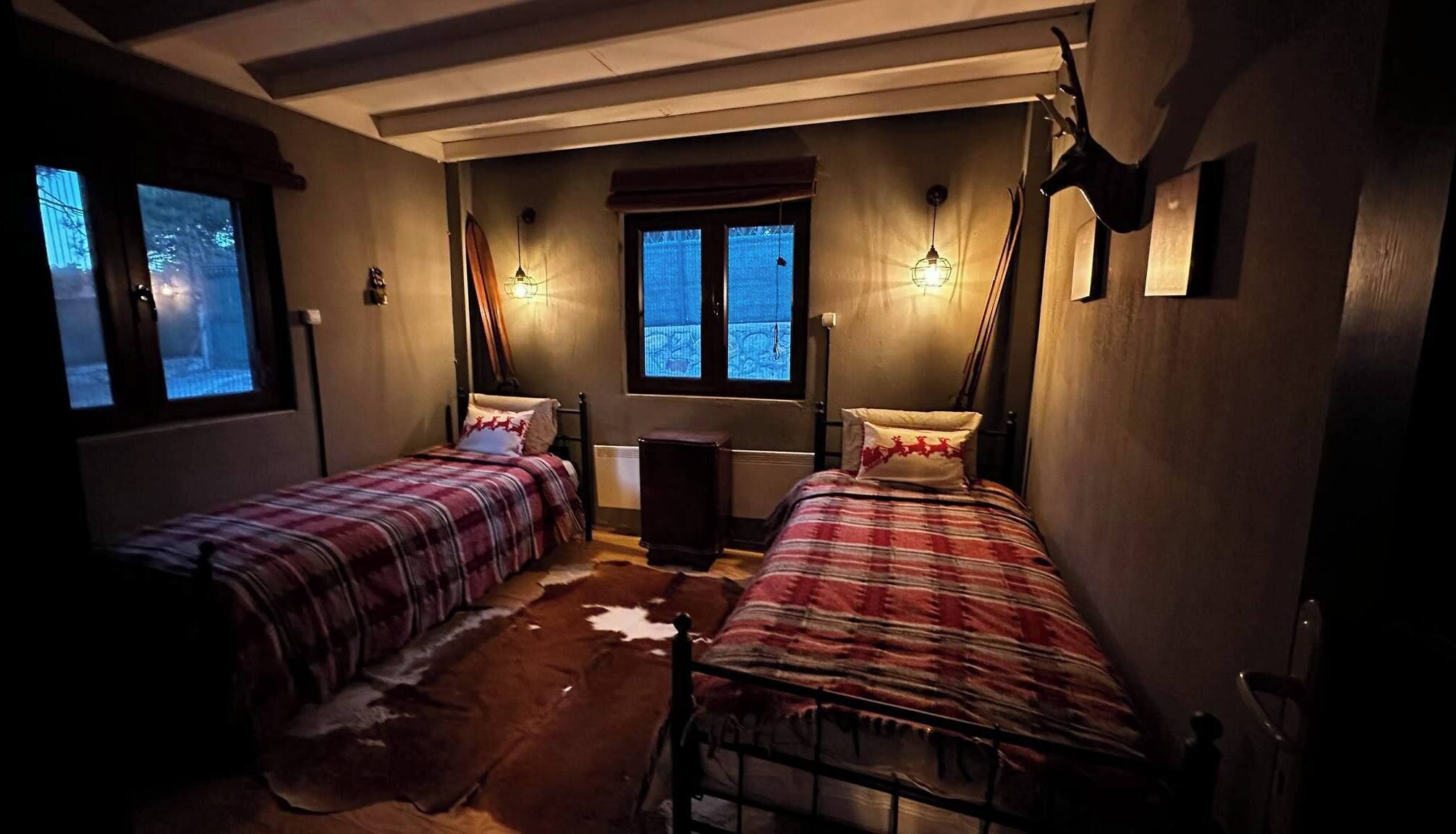 A room with two beds, a window, and a radiator.