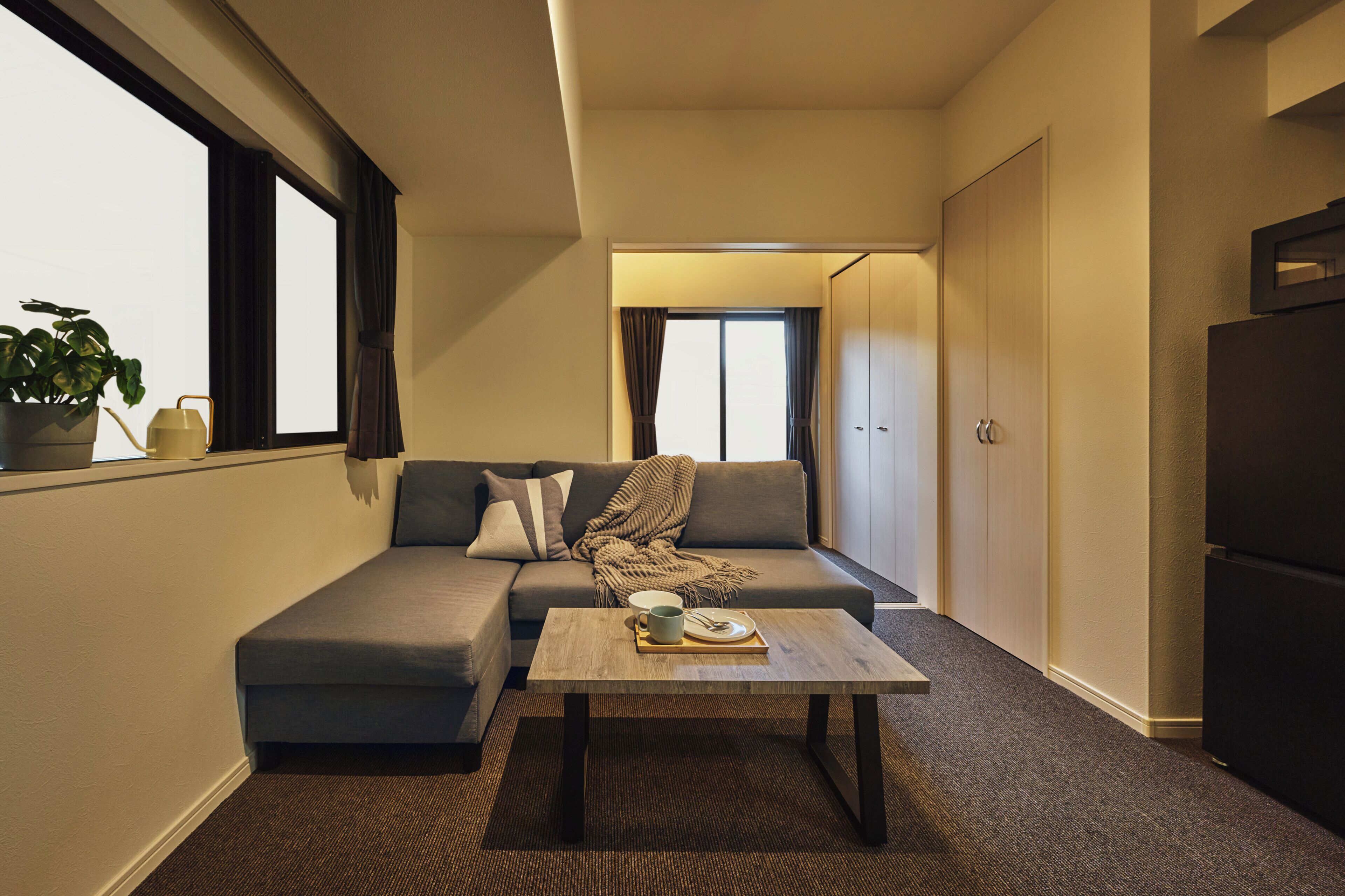 A compact living space with a sofa, a coffee table, and a small dining area.