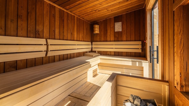 A sauna with wooden benches and a wooden ceiling.
