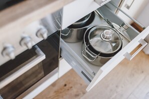 A kitchen with a stove, pots, and a drawer. - Chalet Molly in Zell am See (Zell am See)