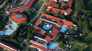 Ilmakuva lomakeskuksesta, jossa on useita rakennuksia, uima-altaita ja maisemoituja alueita.