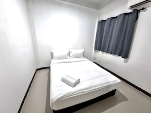 A single bed with white linens, a dark headboard, and a window with grey curtains. - Bob House Khaosan (Bangkok)