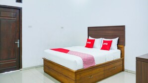 A neatly made bed with a wooden headboard, a white mattress, and red and white pillows. - Luxury Deluxe DBL Retreat W/ Free WiFi and Parking (Bandar Lampung)