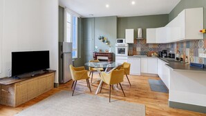 Une cuisine moderne avec un coin repas, un téléviseur à écran plat et une cheminée.