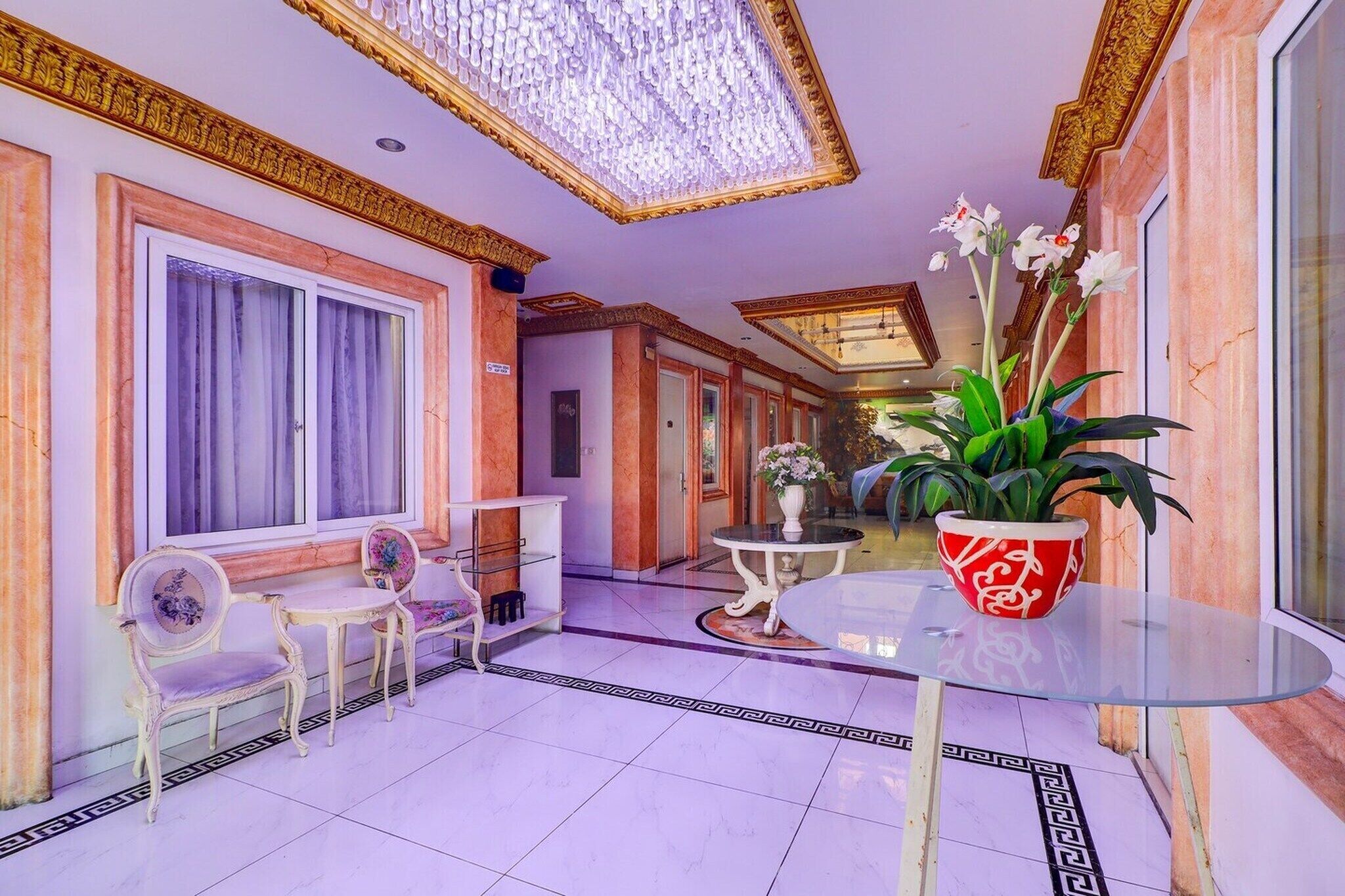 Un hall d’hôtel doté d’un sol en marbre, d’un comptoir d’accueil, d’un espace salon et d’un plafond décoratif.