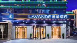 A hotel entrance with a sign reading 'LAVANDE' and a neon sign above. - Lavande Hotel Tianmenshan Branch (Zhangjiajie)