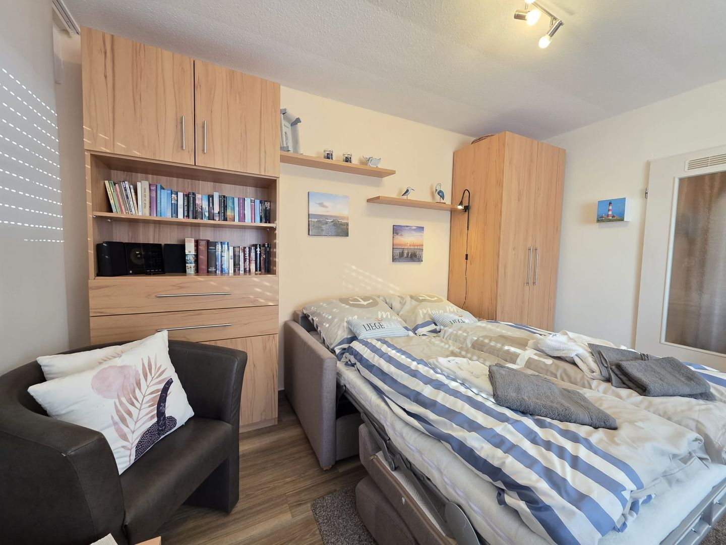 Una camera da letto con un letto, un divano, un armadio in legno e una libreria.