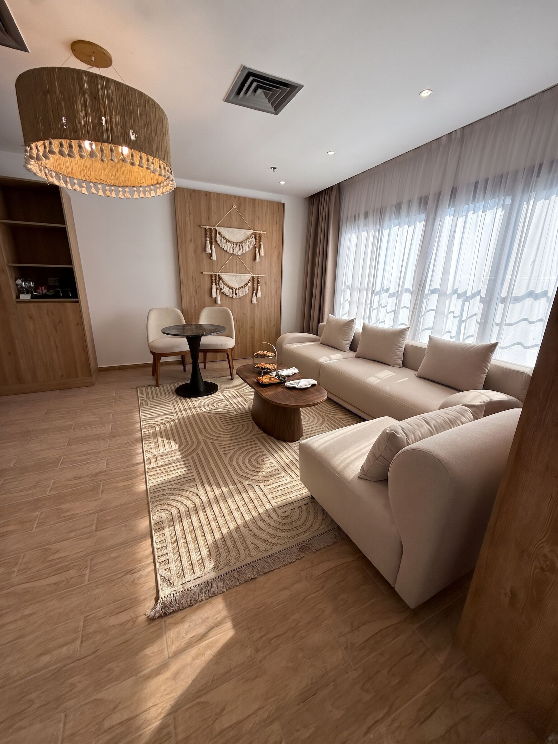 A modern living room with a sofa, a round coffee table, and a dining table with chairs.