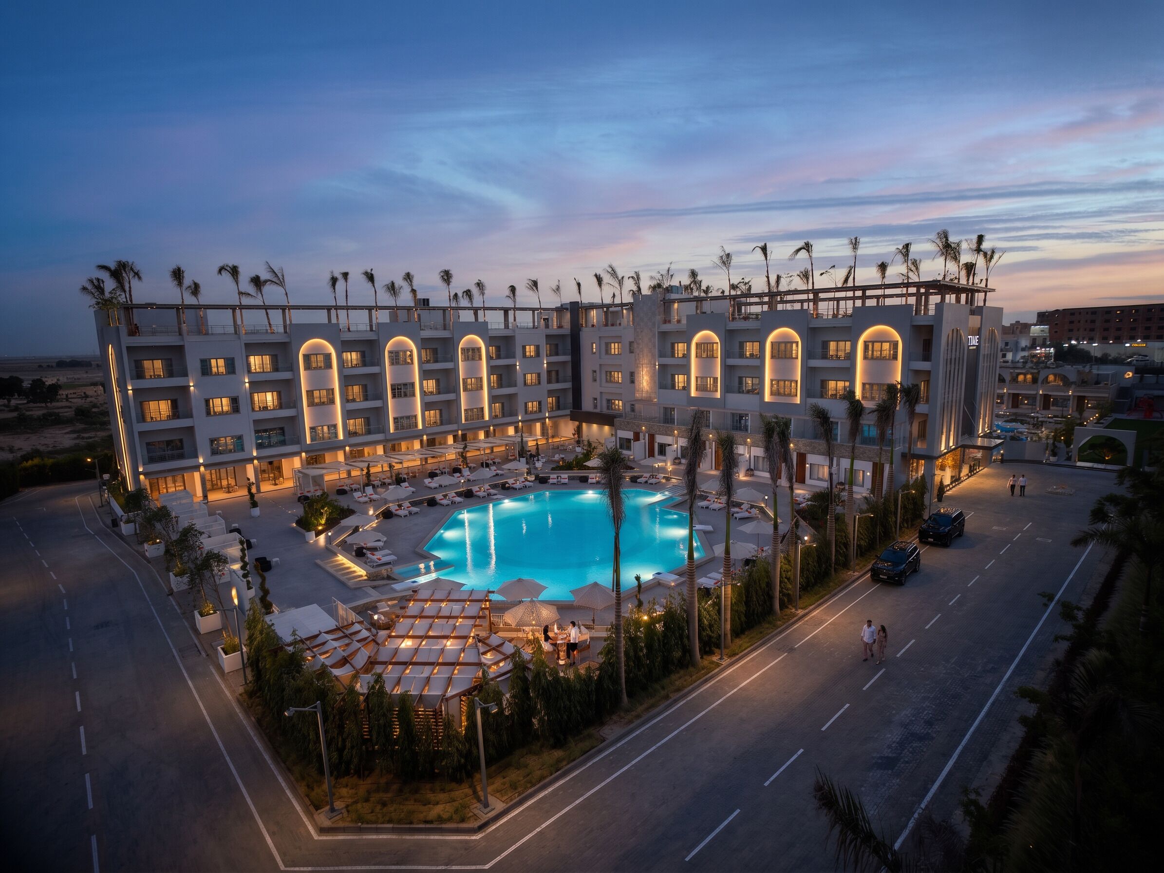 Un hotel con piscina, varios balcones y un diseño arquitectónico moderno.