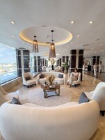 A spacious lobby with a pool view, modern furniture, and a central coffee table.
