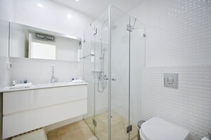 A modern bathroom with a glass-enclosed shower, a white sink, and a toilet. - Lovely 3BR Penthouse in Shenkin area by HolyGuest (Tel Aviv-Yafo)