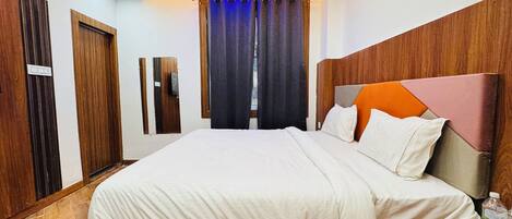 Un dormitorio con una cama, cabecera de madera, cortinas y una lámpara en el techo.