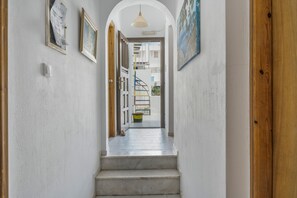 Ein Flur mit einer Treppe, die zu einem offenen Bereich führt.