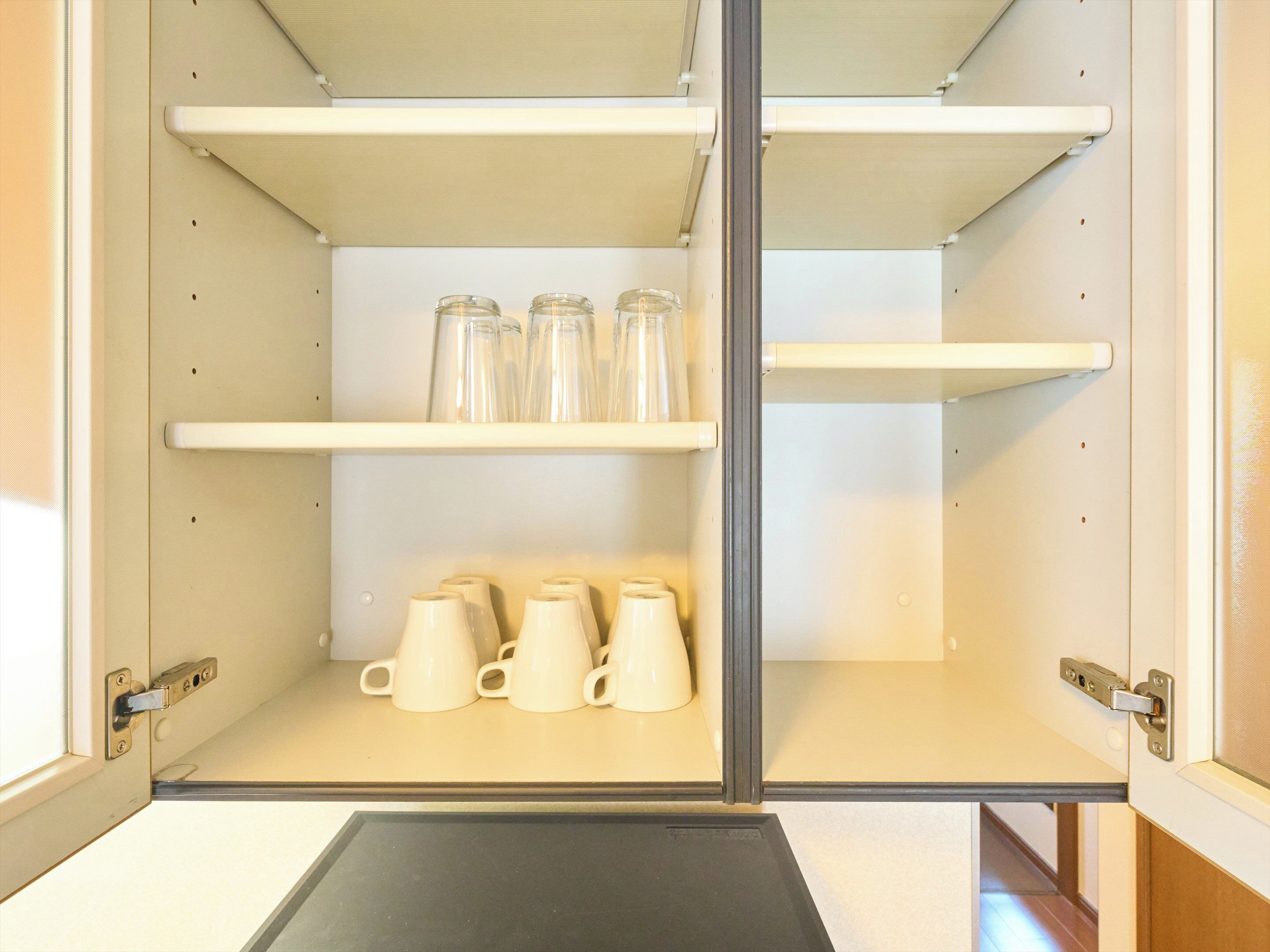 A kitchen with white cabinets, a black countertop, and a door with a silver handle.