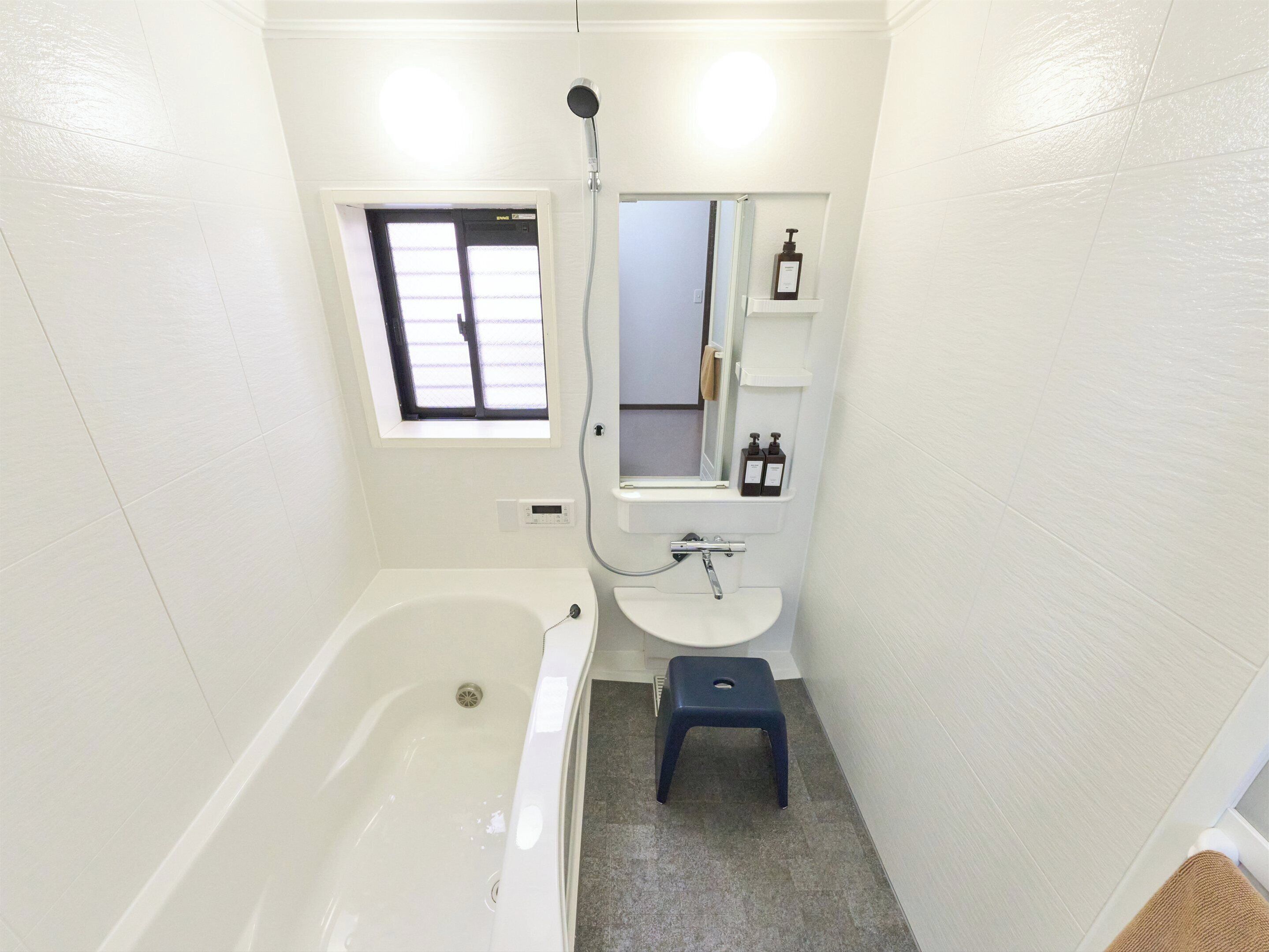 Un baño pequeño con bañera, lavamanos, ventana y espejo.