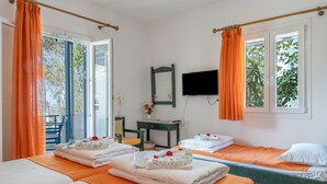 Camera d'albergo con due letti, una scrivania, una sedia, una televisione e un balcone con tende arancioni.