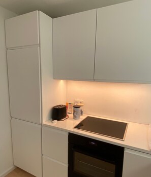 A compact kitchen with a built-in dishwasher, a toaster, and a kettle on the countertop. - Cozy Apartment in Hannover – Near City, Fair, MHH with Balcony and Wi-Fi (Hannover)