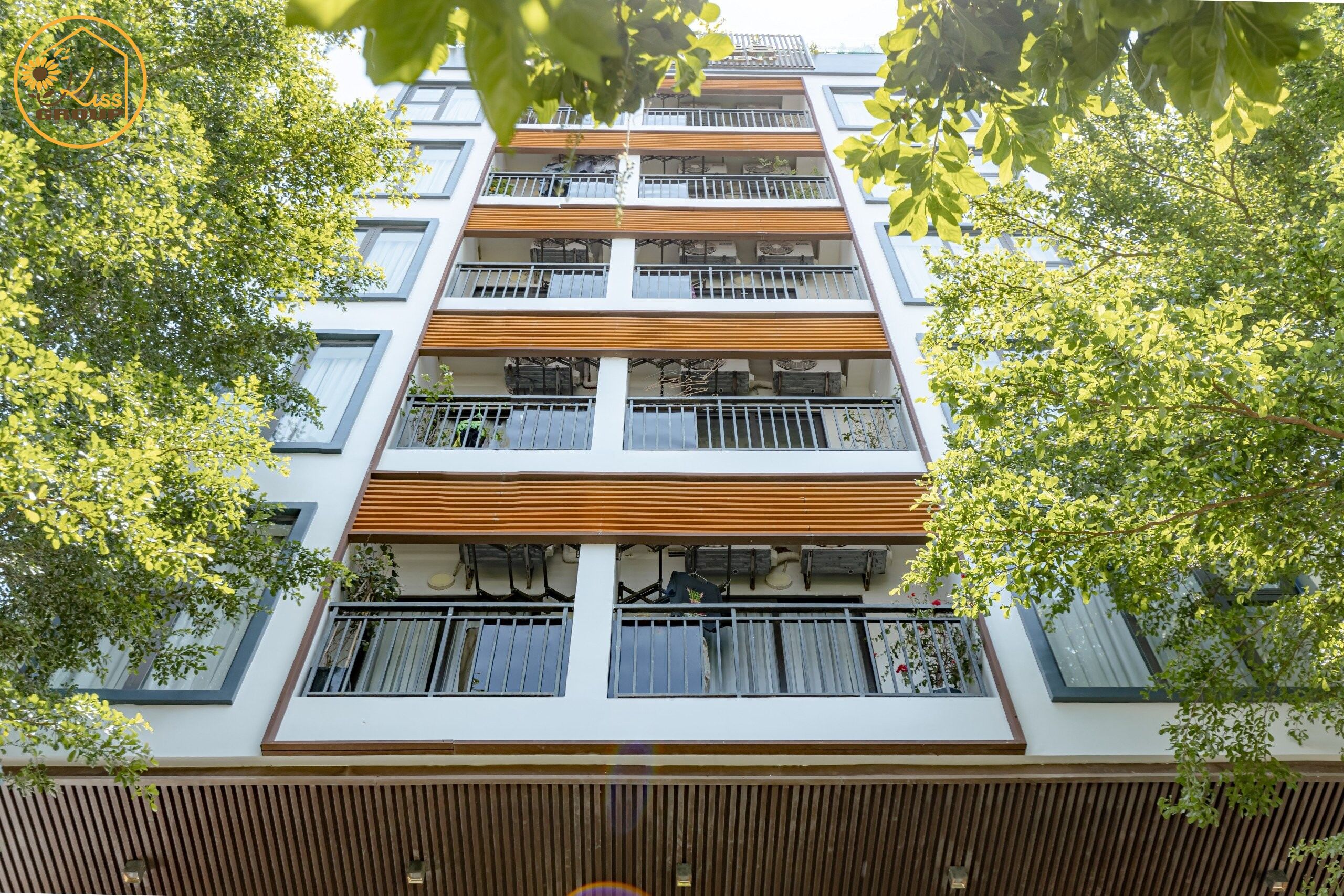 Ein mehrgeschossiges Gebäude mit Balkonen, Fenstern und einer Holzfassade.