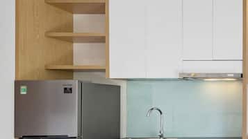 Estudio, vistas a la ciudad | Cocina privada | Frigorífico, microondas, utensilios de cocina y mesa de comedor