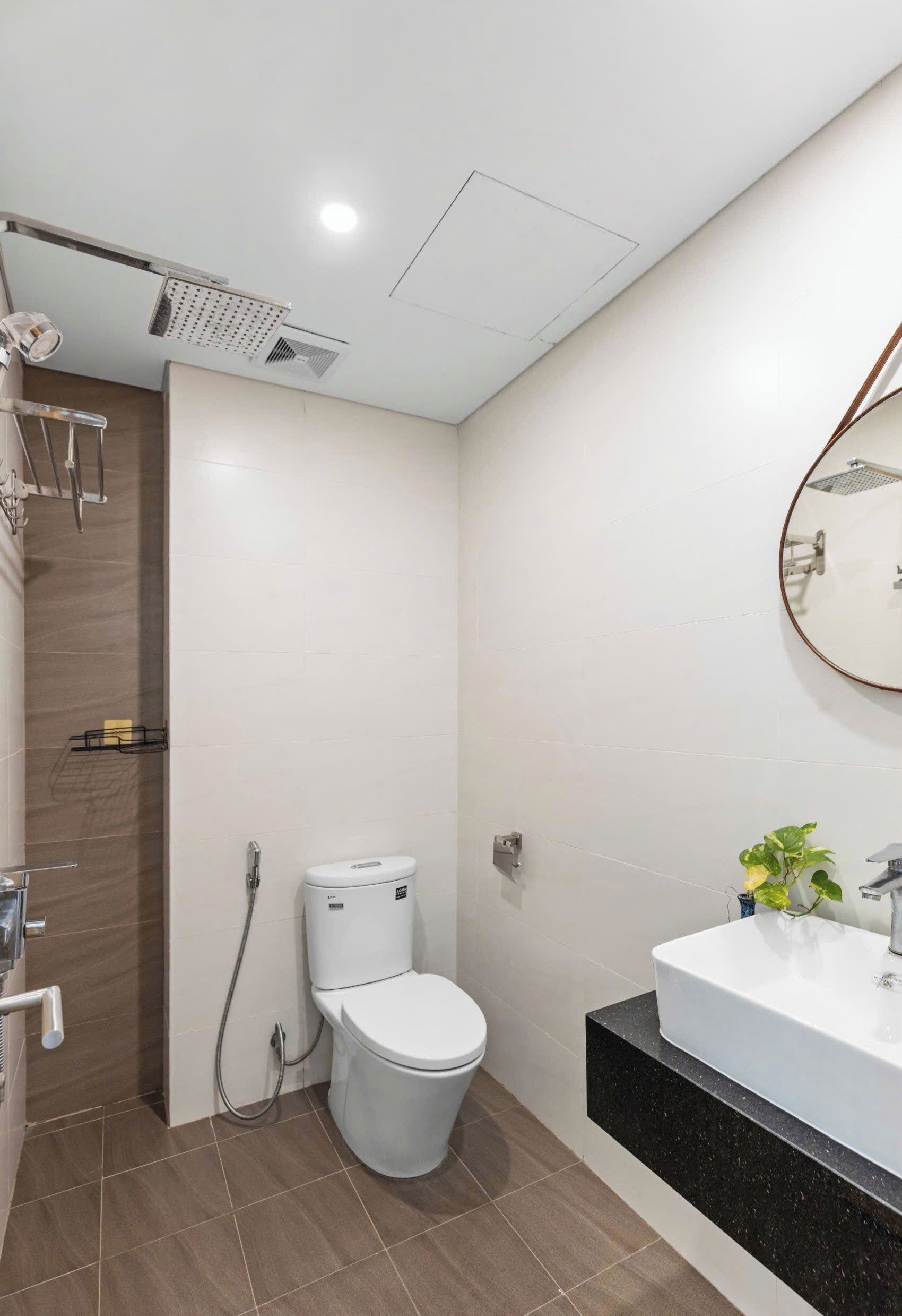 A modern bathroom with a shower, toilet, and sink.
