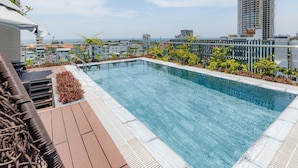 Piscina no terraço com vista para a paisagem urbana.