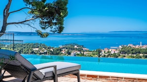 An infinity pool with a view of a coastal town and the sea. - Vila Pantovcak with stunning views by Villas Guide (Mundanije)