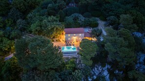 An aerial view of a house with a swimming pool, surrounded by dense forest. - Vila Pantovcak with stunning views by Villas Guide (Mundanije)