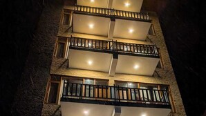 Ett hotell med flera våningar och balkonger, en skylt med texten ”The Glacier Inn”, och en trappa som leder till entrén.