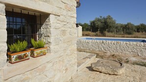 Un bâtiment en pierre doté d’une fenêtre et d’une piscine.