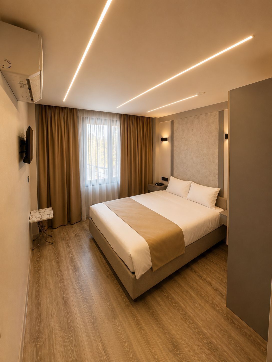 A modern hotel room with a large bed, a bedside table, a wall-mounted TV, and a window with curtains.