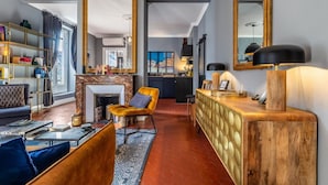Ein modernes Wohnzimmer mit Kamin, einer Couch, einem Couchtisch und einer Holzkommode.
