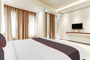 A modern hotel room with a large bed, a flat-screen TV mounted on the wall, and a large window with curtains. - Stylish DBL Suite Escape W/ Free WiFi and Parking (Bali)