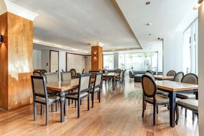 A spacious dining area with wooden tables and chairs, large windows, and a modern ceiling design. - Stylish DBL Suite Escape W/ Free WiFi and Parking (Bali)