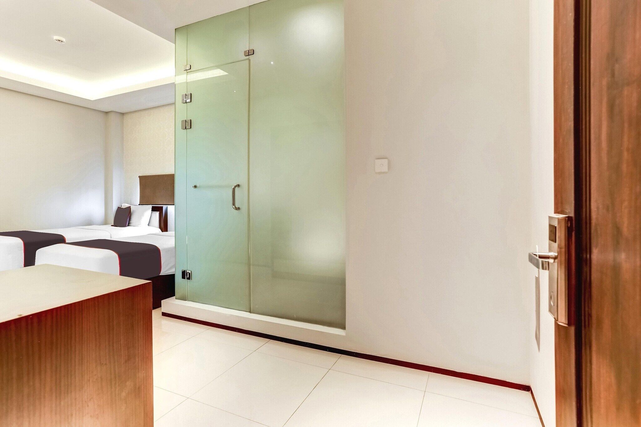 Une chambre d’hôtel comprenant un lit, un bureau, une armoire et un miroir.